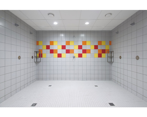 Salle de douche carrelée avec des accents colorés et des rigoles d''évacuation