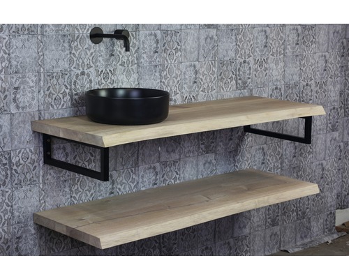 Salle de bains avec deux étagères en bois, vasque à poser noire et robinet devant un mur à motifs