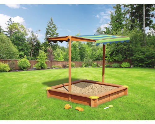 Bac à sable avec toit pare-soleil et jouets dans le jardin