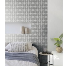 Schlafzimmer mit gemusterter Tapete, Bett und Beistelltisch.