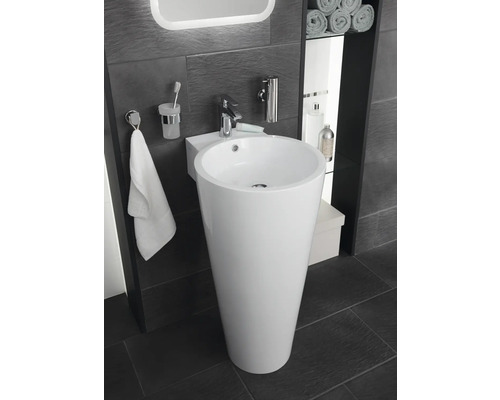 Salle de bains avec lavabo sur pied, robinet, porte-serviettes et accessoires.