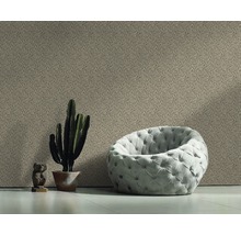 Pièce décorative avec papier peint à motifs, fauteuil, cactus et figurine décorative