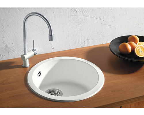 Scène de cuisine avec évier rond et robinet sur une surface en bois