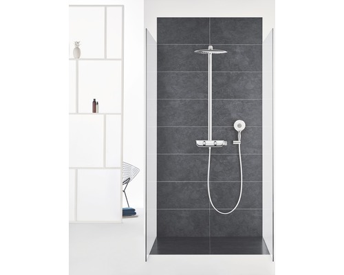 Dusche mit Kopf- und Handbrause vor grauer Fliesenwand