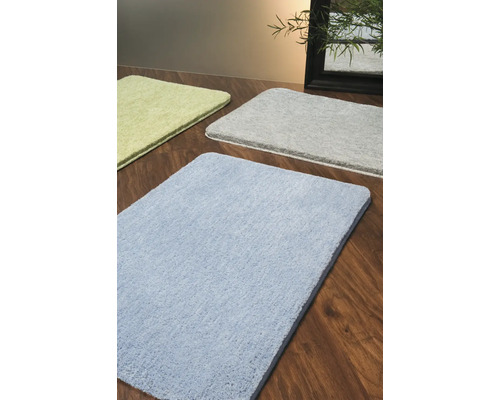 Tapis de bain de différentes couleurs sur plancher en bois