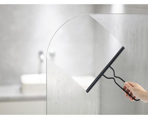 Main essuyant une paroi de douche avec un racloir à vitre