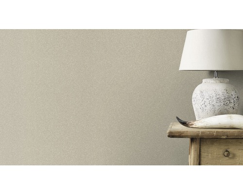 Gros plan d''un papier peint à motifs subtils à côté d''une table de chevet avec une lampe