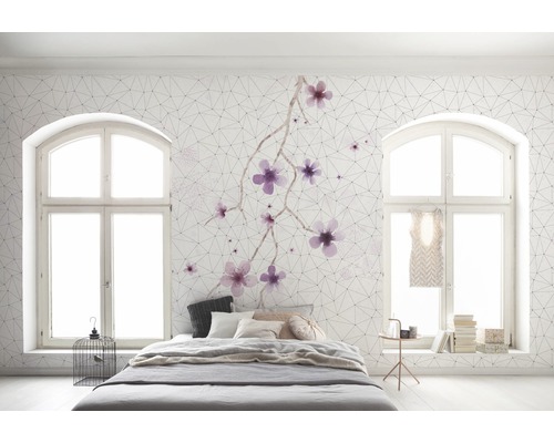 Chambre claire avec lit, fenêtres et papier peint à motifs floraux