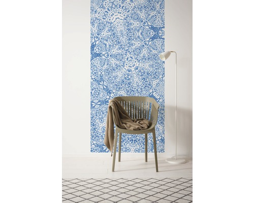 Pièce avec un papier peint à motifs, une chaise, une couverture, un lampadaire et un tapis