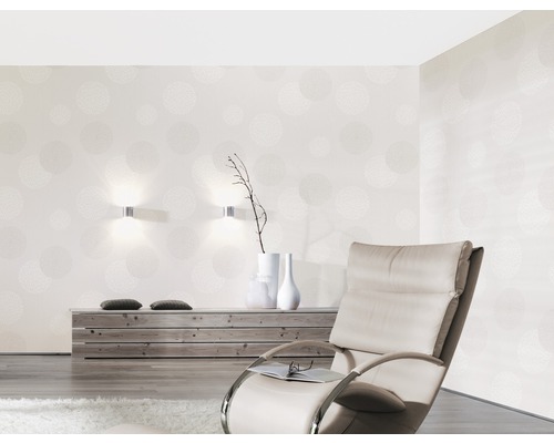 Wohnzimmer mit gemusterter Tapete, Sessel und Holzkommode