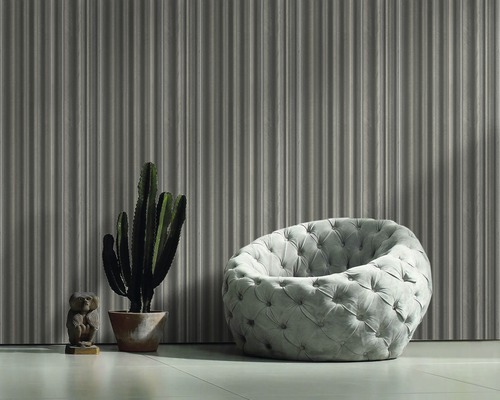 Szene mit gerippter Wandtapete, Sessel, Kaktus und Bärenfigur.