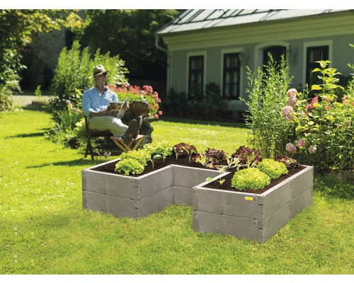 Jardinière surélevée classique JUWEL Timber ErgoLine 185 x 40 x 125 cm aspect bois Jardinière surélevée en plastique dans un jardin avec un homme assis