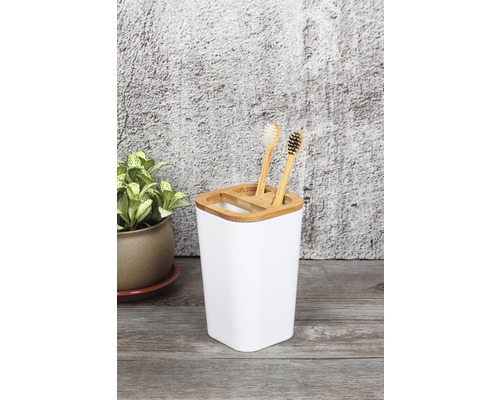 Scène de salle de bains avec gobelet à brosses à dents blanc et brosses à dents