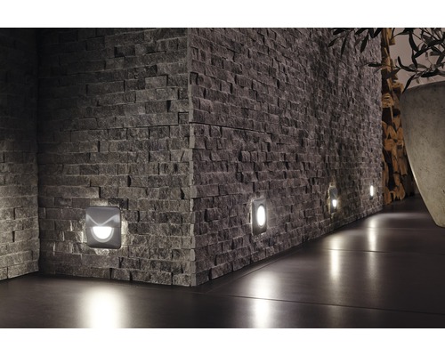 Wand mit Natursteinen und eingelassenen Wandleuchten