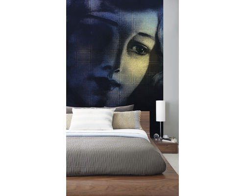 Chambre à coucher avec papier peint photo d''un visage de femme derrière un lit en bois.