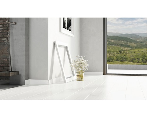 Pièce lumineuse avec plancher en bois clair, deux cadres photo et un bouquet de fleurs.