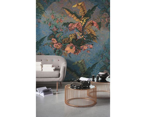 Dekoratives Wohnzimmer mit gemusterter Tapete, Sofa und Beistelltischen.