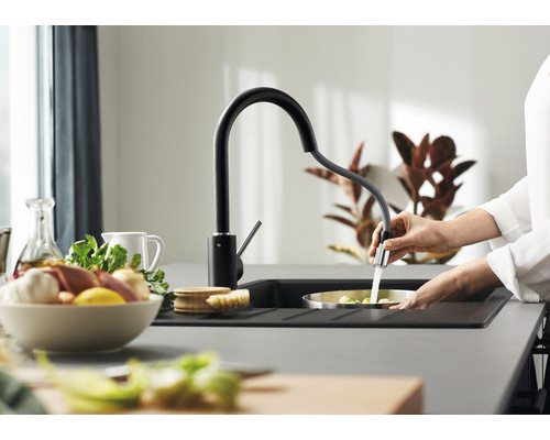 Scène de cuisine avec robinet d''évier, évier et personne lavant des légumes