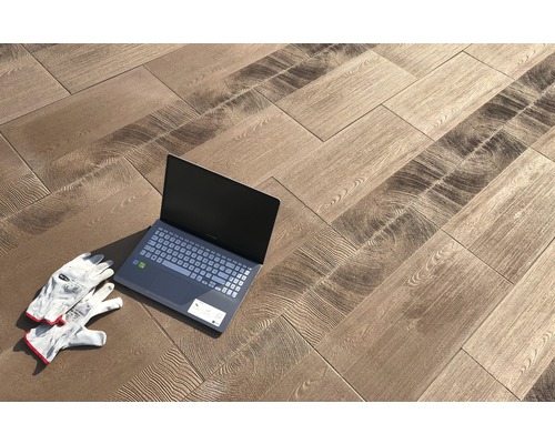 Pose de carreaux de sol imitation bois avec ordinateur portable et gants de travail