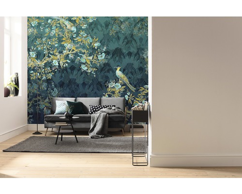 Salon avec canapé devant un papier peint à motifs avec des motifs de plantes et d''oiseaux