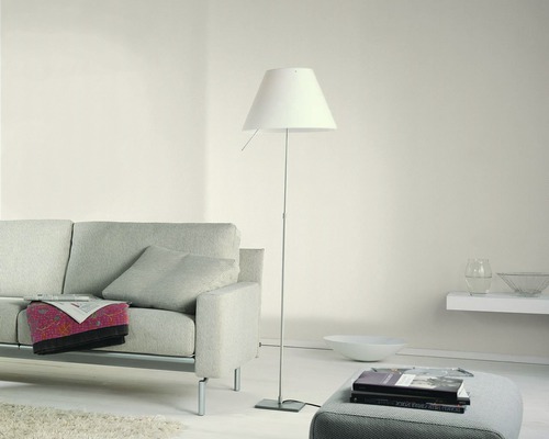 Wohnzimmer mit Sofa, Stehlampe und Hocker