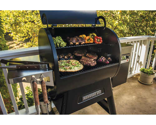 Barbecue avec pizza, steaks, légumes et côtes levées sur la grille