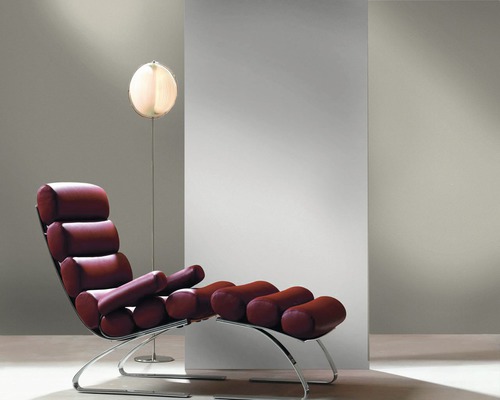 Lesesessel mit Stahlrahmen und gepolsterter Sitzfläche neben einer Stehlampe