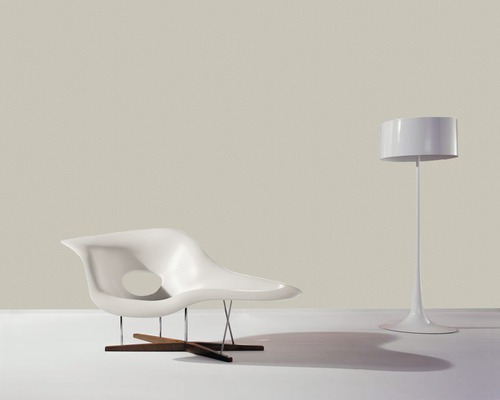 Szene mit Loungesessel aus Kunststoff und Holz sowie Stehlampe