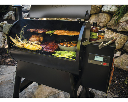 Abbildung eines schwarzen Grills mit Speisen wie Steak, Hähnchen, Rippchen, Maiskolben, Spargel und Gemüse.