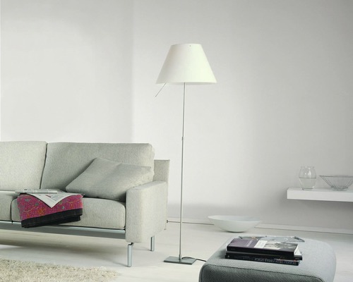 Salon avec lampadaire, canapé et tabouret pour une ambiance claire et organisée