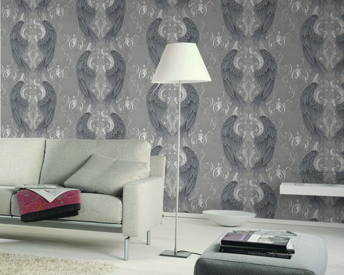 Salon avec papier peint gris à motif d''ailes, canapé et lampadaire.