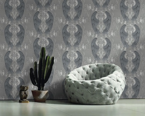 Salon avec papier peint à motif d''ailes, fauteuil, cactus et décoration