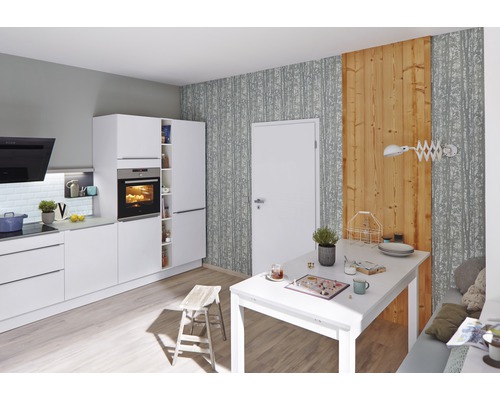 Cuisine lumineuse avec des meubles blancs et une table à manger.