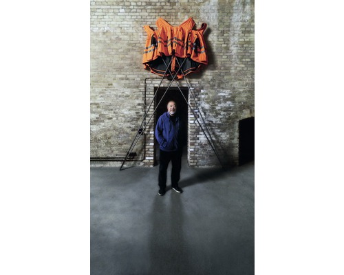Livre « anglais » Ai Weiwei & HORNBACH – « Safety Jackets Zipped the Other Way » Installation avec des gilets de sécurité et des tiges métalliques devant un mur de briques