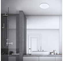 Badezimmer mit Dusche, Waschbecken und runder Deckenleuchte