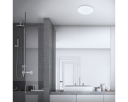 Badezimmer mit Dusche, Waschbecken und runder Deckenleuchte