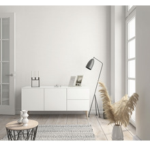 Salon lumineux avec commode, lampadaire et articles de décoration