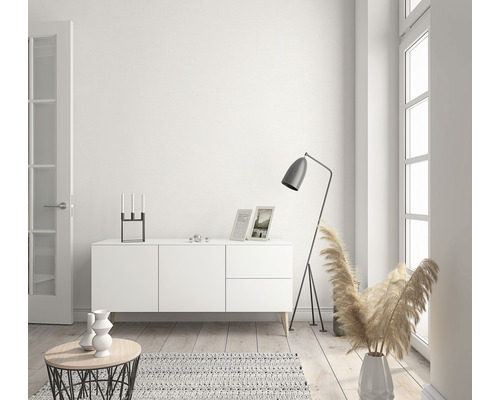 Heller Wohnraum mit Kommode, Stehlampe und Dekorationsartikeln