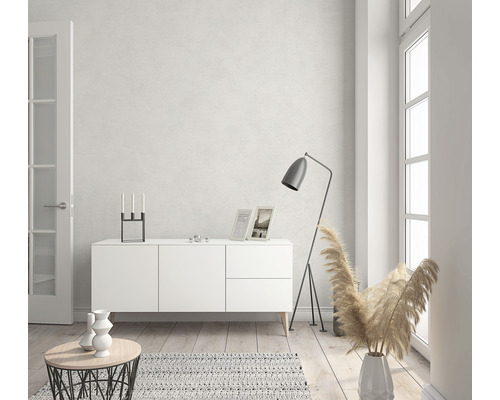 Helles Wohnzimmer mit weissem Sideboard, Stehlampe und Dekorationen.