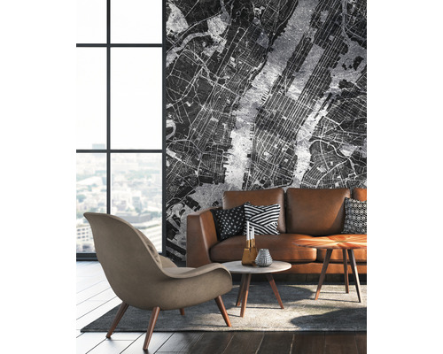 Salon avec canapé marron, fauteuil et papier peint avec plan de ville