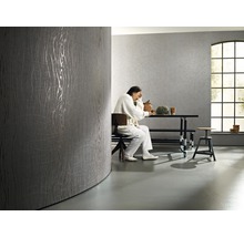 Pièce lumineuse avec papier peint design gris et personne assise à table