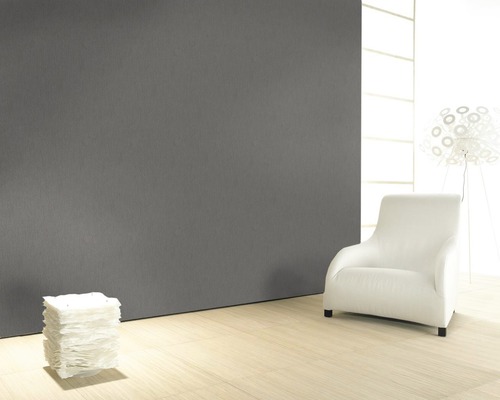 Modernes Zimmer mit grauer Wand, hellem Holzboden, weißem Sessel und Lampe.