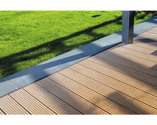 Gros plan d''une terrasse en bois à côté d''une pelouse et d''une bordure