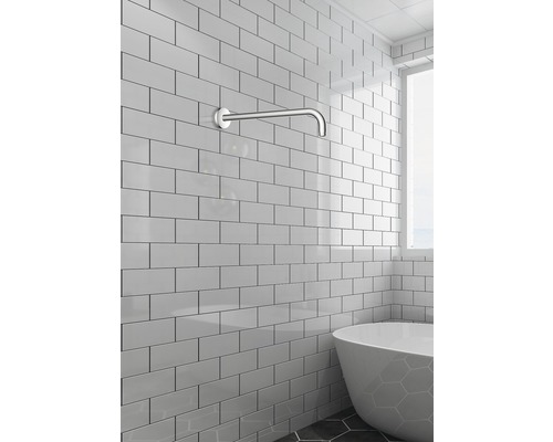 Badezimmer mit Wandarm für Badewanne und weißen Fliesen