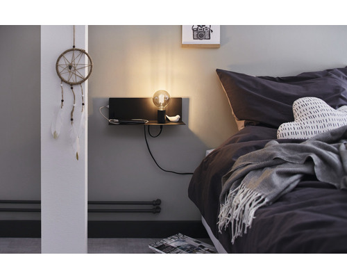 Chambre avec lit, table de chevet, lampe et attrape-rêves