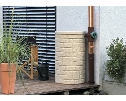 Récupérateur d''eau de pluie aspect pierre à côté d''une descente pluviale sur une terrasse