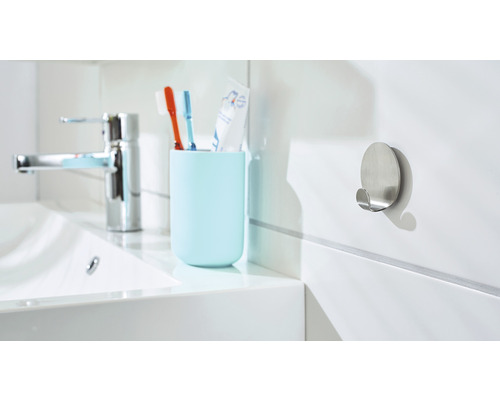 Salle de bains moderne avec lavabo, robinet, porte-brosse à dents et patère en métal