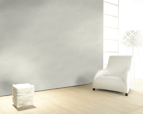 Helles Zimmer mit Sessel, Lampe und strukturierten Wänden