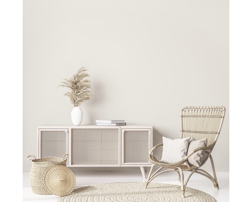 Scène de salon avec commode, fauteuil en rotin, tapis et décorations pour une ambiance lumineuse et conviviale
