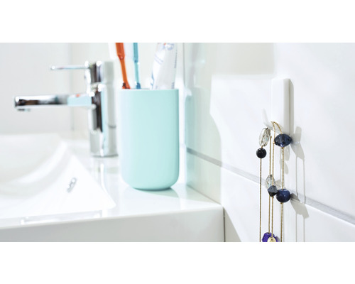 Salle de bain claire avec lavabo, gobelet pour brosses à dents et crochet mural avec collier